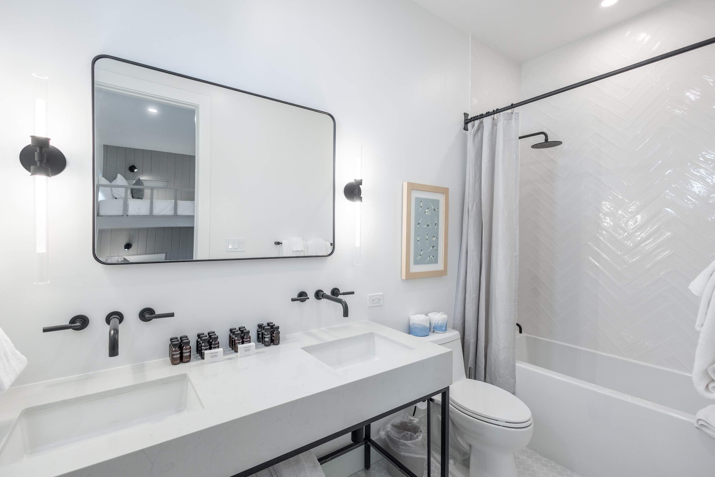 Une salle de bain moderne avec un grand miroir, deux lavabos, une douche et des toilettes.