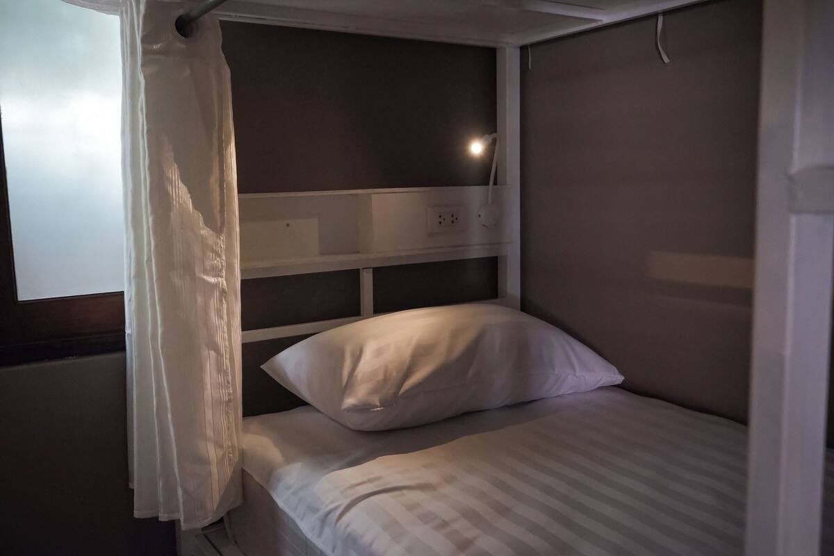 A single bed with a white headboard and a white pillow.