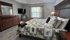 A bedroom with a large bed, a dresser, a television, and a ceiling fan. - Christmas Condo w/ garage just off the Parkway in Pigeon Forge, TN (Pigeon Forge)
