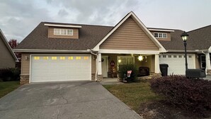 A residential house with a garage, a covered porch, and a well-maintained lawn. - Christmas Condo w/ garage just off the Parkway in Pigeon Forge, TN (Pigeon Forge)