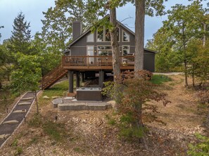 A modern two-story house with a deck, a hot tub, and a stone pathway leading to the entrance. - On The Rocks by Innsbrook Vacations! (Innsbrook)