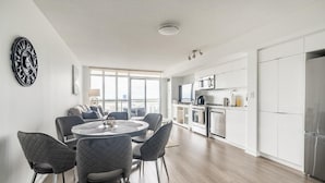 A modern apartment with a dining area, kitchen, and large windows. - GLOBALSTAY. Bird's eye view of the lake 1bd+den in Downtown (Toronto/Canada)