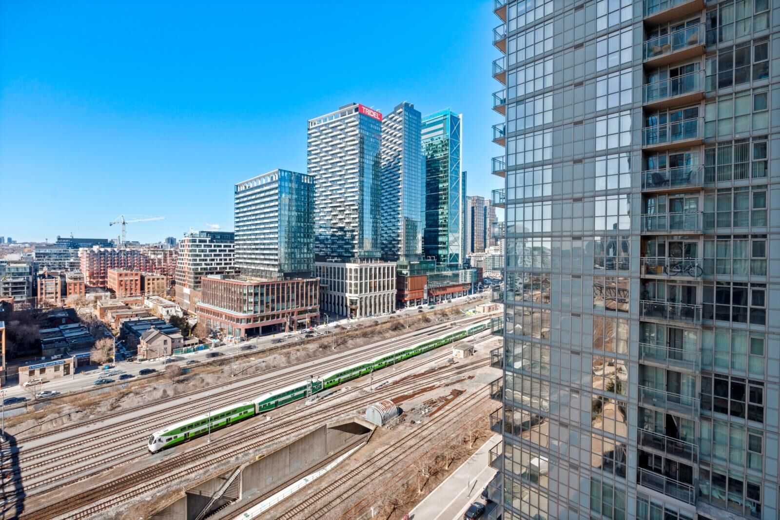 A high-rise building with a modern glass facade and a visible "TRIDEL" sign.
