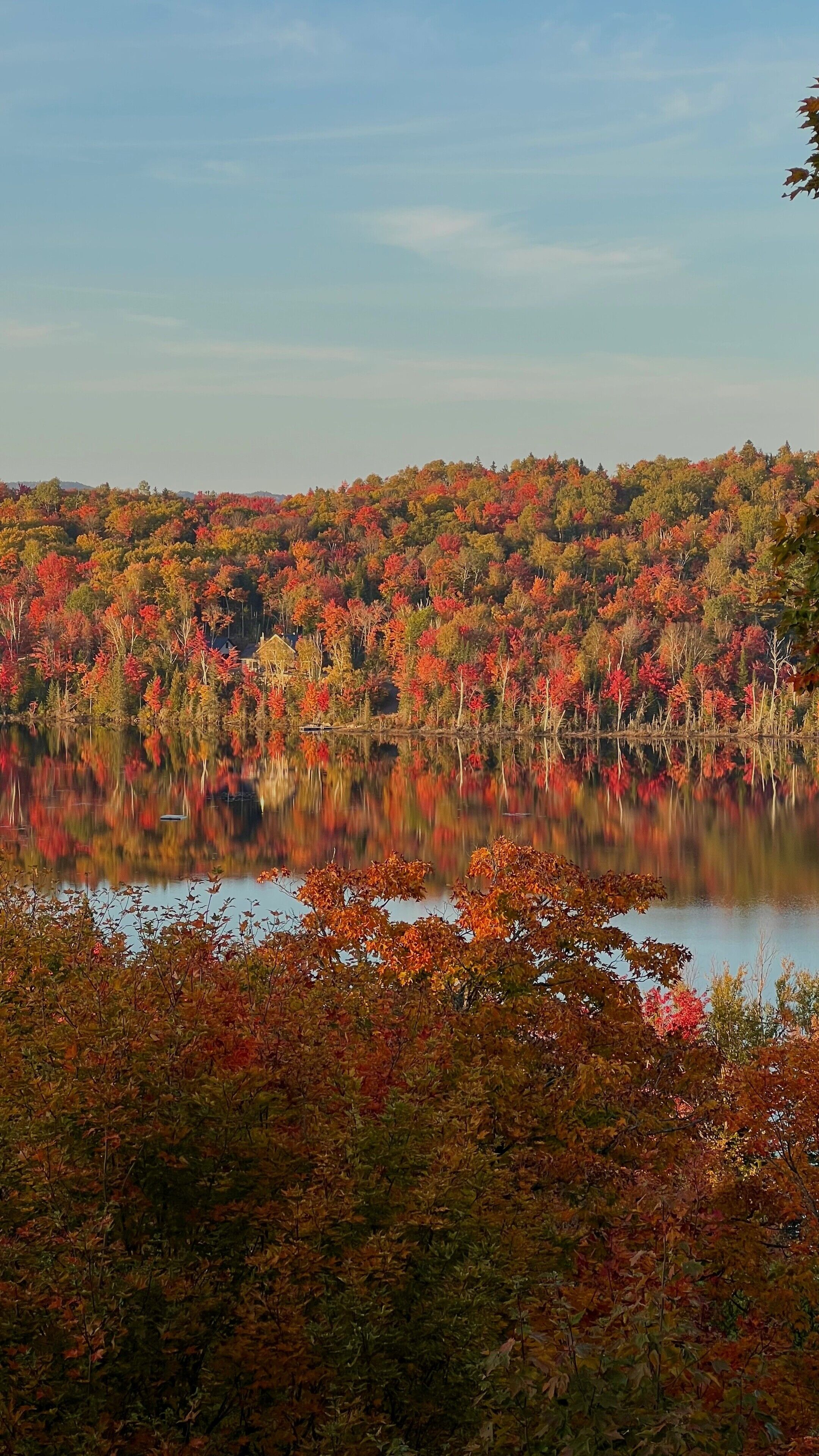 A lake surrounded by autumn foliage with reflections on the water.