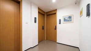 Ein Flur mit Holztüren und einem gerahmten Gemälde an der Wand.