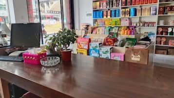 A counter with a computer, a potted plant, and various packaged goods.