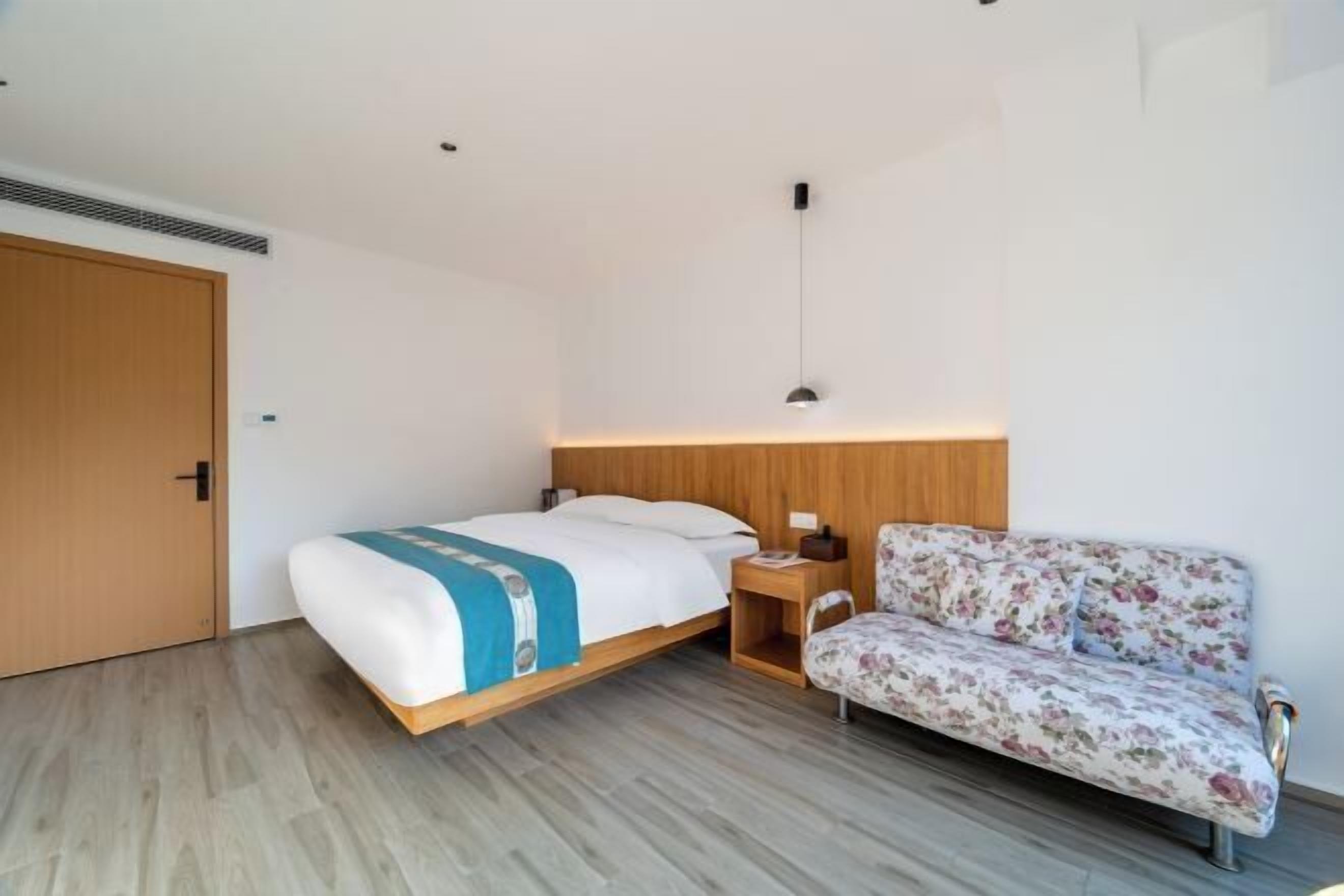 Une chambre à coucher comprenant un lit, une table de chevet, une commode et un canapé.