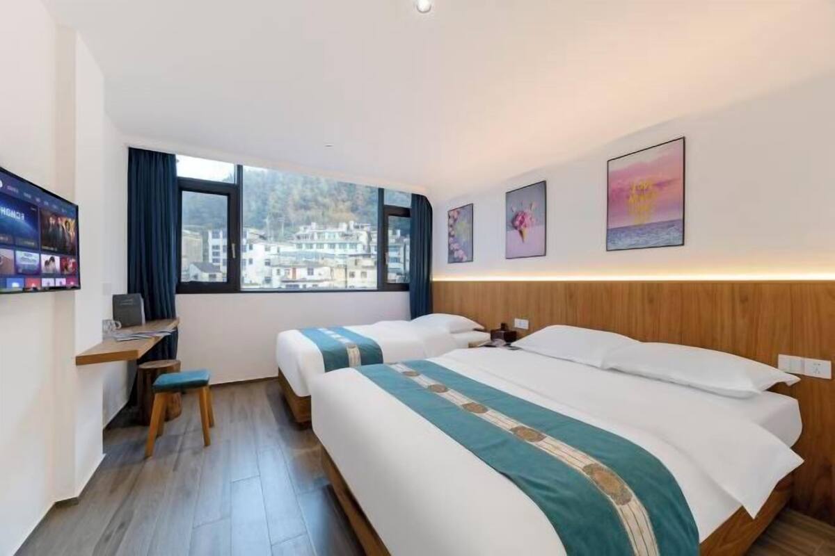 Une chambre d’hôtel avec un lit, un bureau, une chaise et un téléviseur.