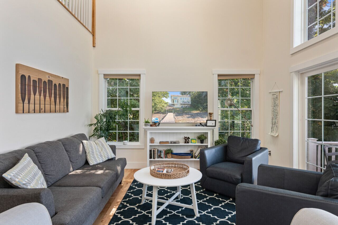 A modern living room with a grey sofa, a coffee table, and a bookshelf.