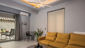 A modern living room with a sofa, a coffee table, and a dining area with a table and chairs. - Casa Amarillo is the perfect place for your holidays (Chania)