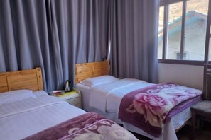 A room with two beds, a window, and curtains. - Jiangling Inn (Songpan)