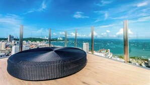 A modern, circular black seating area with a panoramic city and ocean view. - Kaws Theme - Luxury Modern Cozy Art l Infinity Pool l Central Pattaya



 (Bang Lamung District Muang Pattaya)