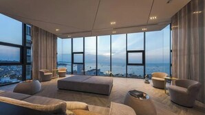 A modern living room with large windows, a sofa set, and a coffee table. - Kaws Theme - Luxury Modern Cozy Art l Infinity Pool l Central Pattaya



 (Bang Lamung District Muang Pattaya)