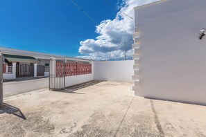 A building with a gated entrance, a covered area, and a clear sky. - 4030 Villetta Giovy by Barbarhouse (Porto Cesareo)