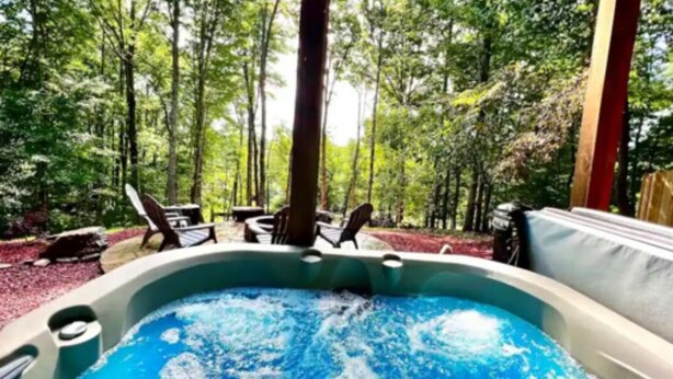 Un jacuzzi rodeado de árboles en un área boscosa.