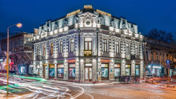 A historic hotel with ornate architecture, a prominent entrance, and a well-lit facade. - Monument1880 (Tbilisi)