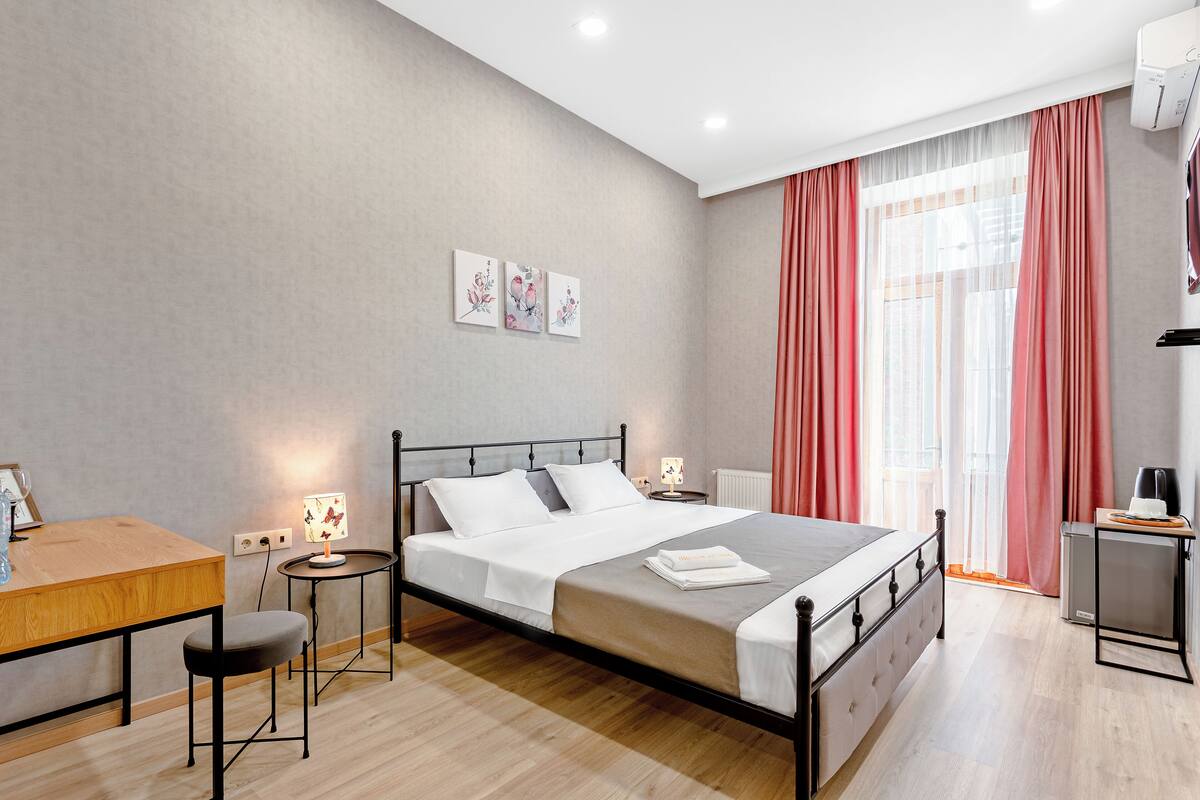 Ein modernes Schlafzimmer mit Bett, Nachttischen, Schreibtisch und Stuhl.