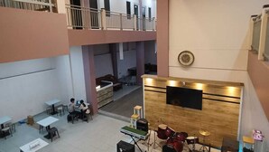 A multi-level atrium with a music studio on the lower level, featuring a drum set and keyboard. - Karana Guesthouse Syariah Bandung & Luang Cafe (Bandung)