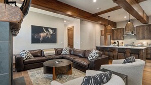 Una sala de estar moderna con un sofá modular, una mesa de centro redonda y un sillón gris.