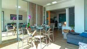 A modern open-plan living space with a dining area, kitchen, and seating area.