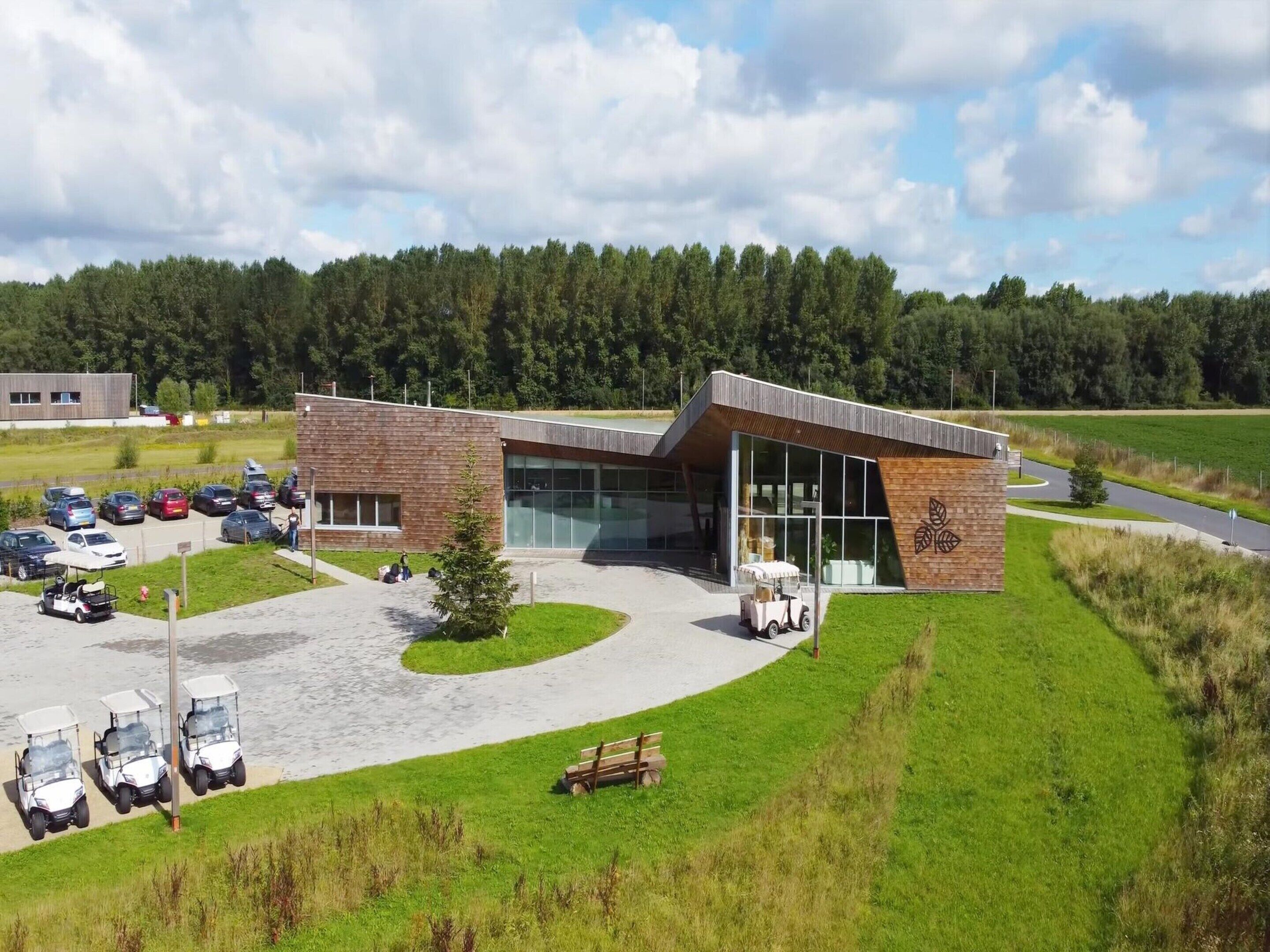 A modern building with a parking area and golf carts.