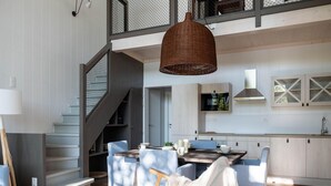 A modern kitchen with light wood cabinets, a built-in oven, and a hanging wicker light fixture. - Elegant Mansion in Nature (Antoing)