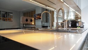 Une cuisine moderne dotée d’un grand îlot central, d’appareils électroménagers en acier inoxydable et d’un robinet élégant.