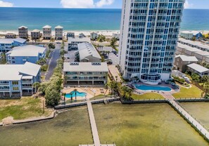 A high-rise hotel with a pool, beach view, and multiple buildings. - The Landing 213 (Gulf Shores)