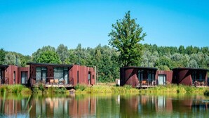 Un chalet au bord du lac, doté d’une terrasse et d’un espace salon extérieur abrité.