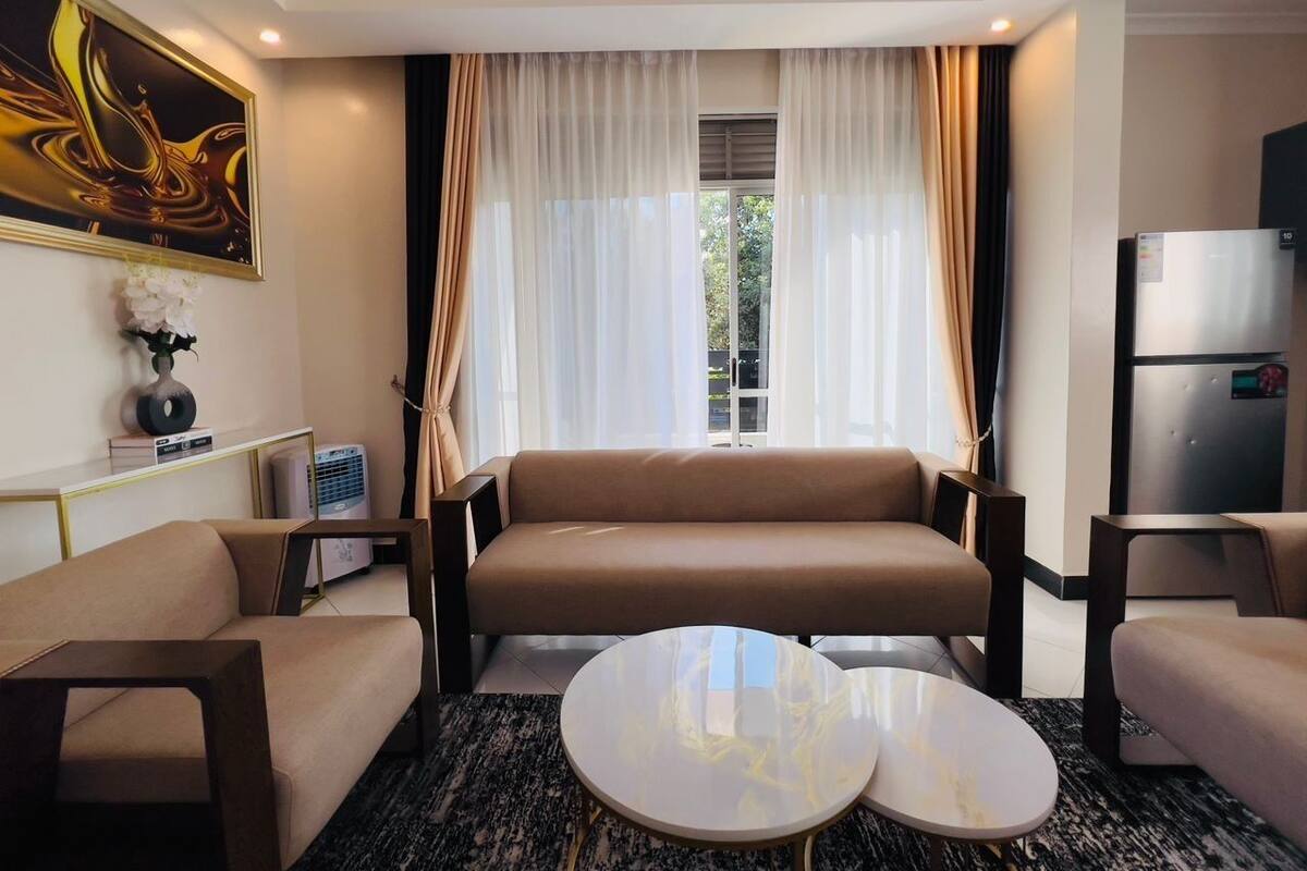 A modern hotel room with a sofa set, a coffee table, and a refrigerator.