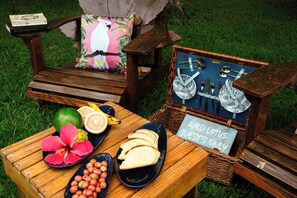 A picnic setup with a wooden bench, a wicker basket, and a sign that reads "WILD LOTUS GUESTS ONLY".