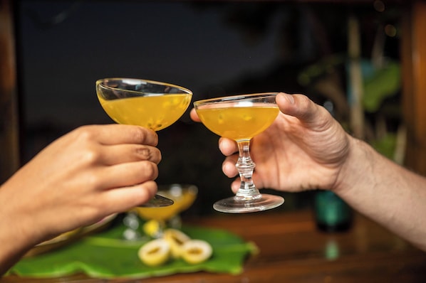 Two hands holding cocktail glasses.