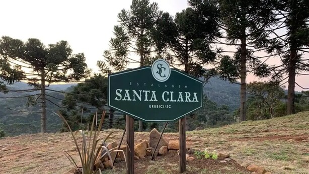 Señal de Santa Clara Estate, rodeado de rocas y vegetación escasa.
