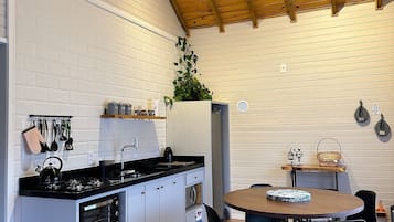 Presidentieel huisje, open haard, uitzicht op tuin | Privékeuken | Een koelkast, een magnetron, kookgerei, borden en bestek, eettafels