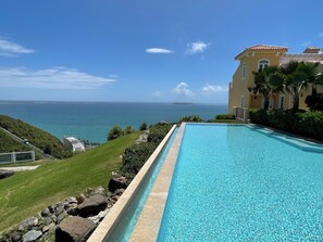 A swimming pool with a clear view of the ocean and a distant island. - 2Bed 2Bath at Las Casitas Village Fajar (Fajardo)