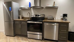 A modern kitchen with stainless steel appliances, a built-in oven, and a dishwasher.