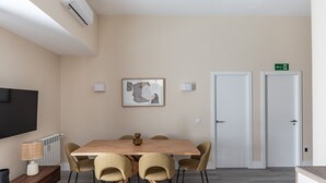 Una sala conferenze con un grande tavolo, sedie, una TV a parete e un quadro incorniciato appeso al muro.