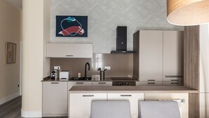 Una cucina moderna con isola centrale, mobili a incasso e lampadario a sospensione.