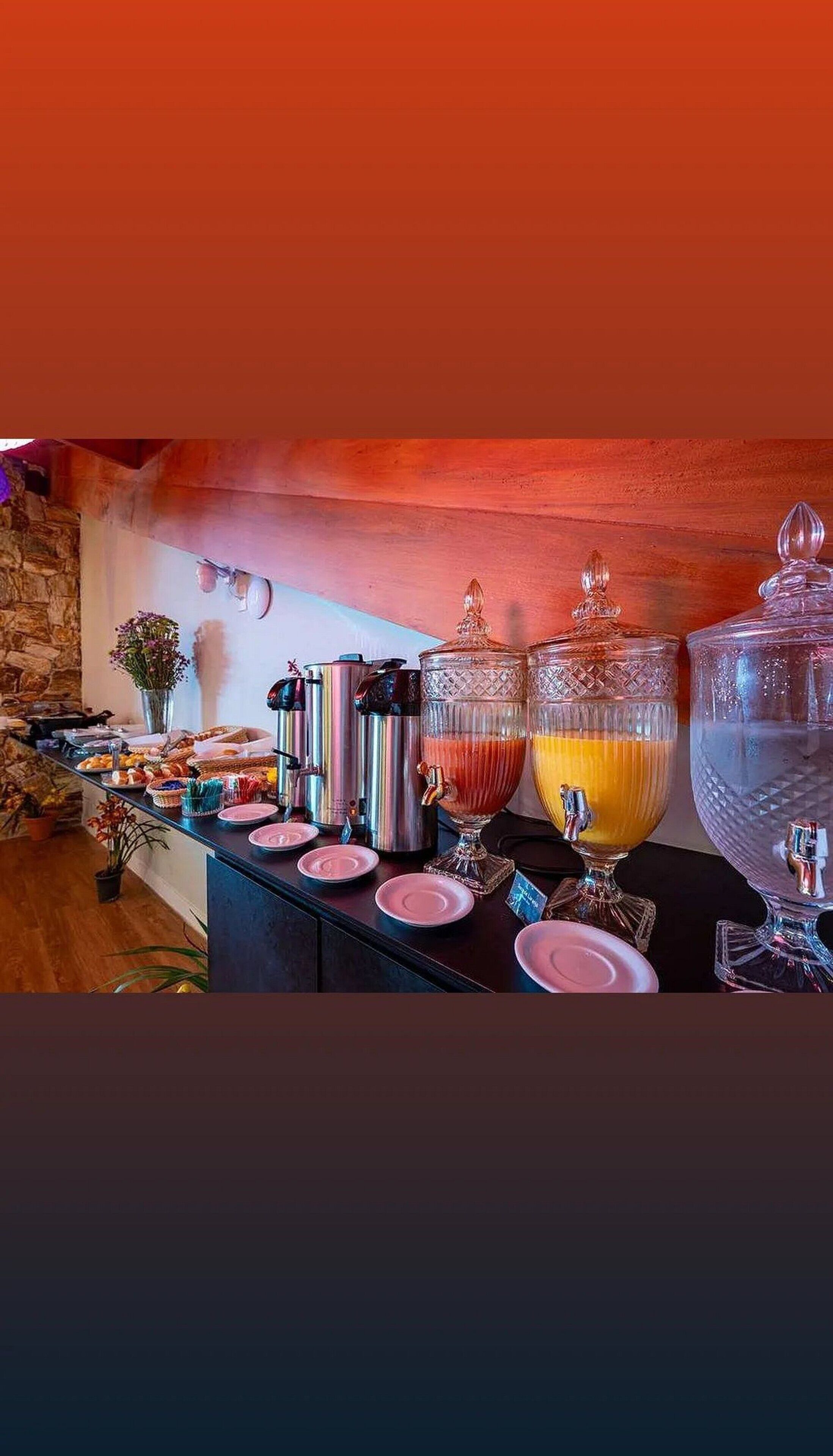 Een buffetopstelling met diverse gerechten en drankjes, waaronder een grote fruitschaal en verschillende bakken.