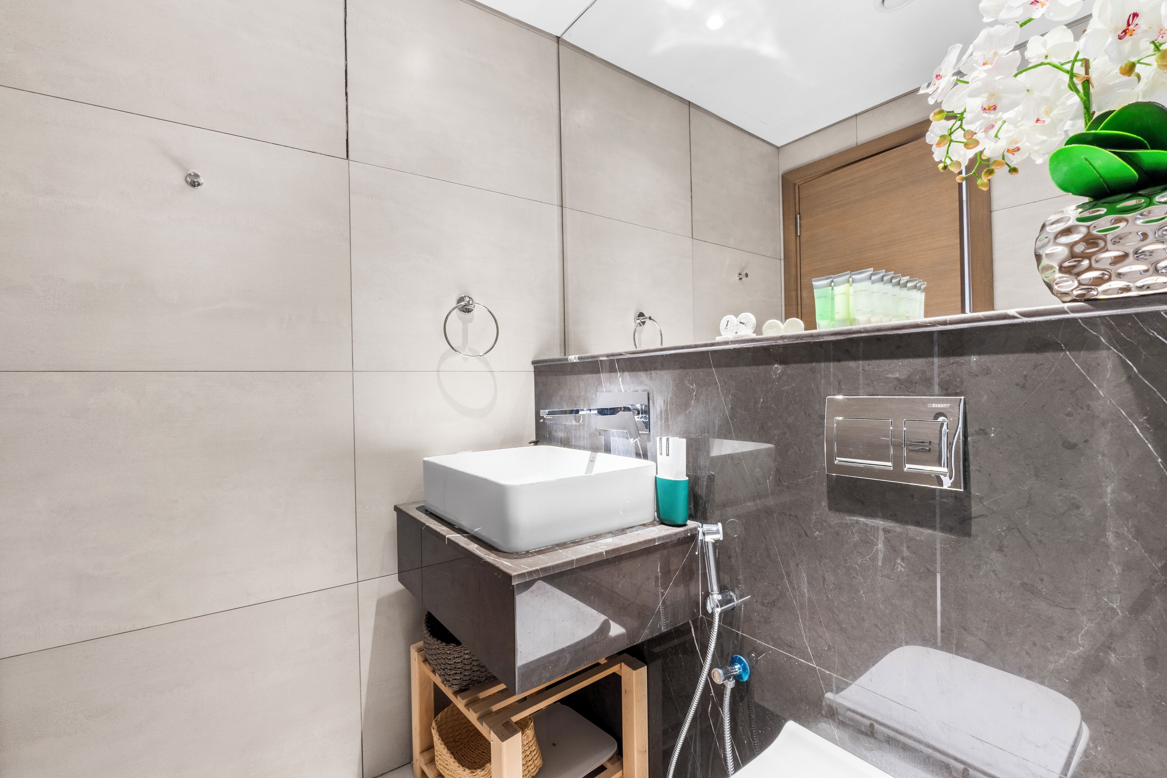 A modern bathroom with a large sink, a mirror, and a shower.