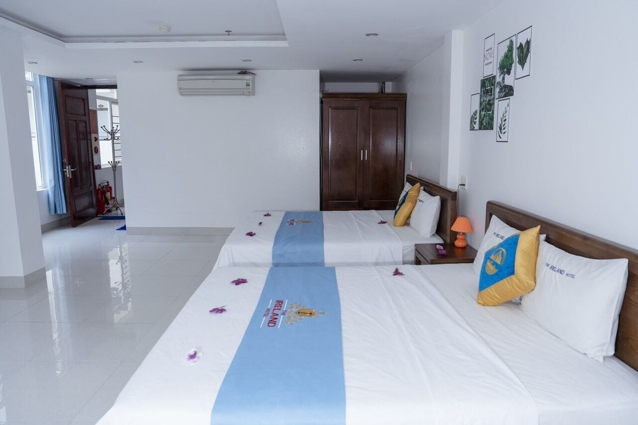 Une chambre d’hôtel avec deux lits, une armoire et un climatiseur fixé au mur.