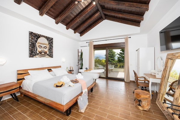 Ein Schlafzimmer mit einem hölzernen Bett, einem Schreibtisch, einem Stuhl, einem Fernseher und einem Balkon mit Blick.