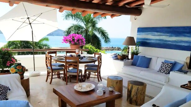 A sunlit patio with a dining table, chairs, and a sofa. - Villa Frente al Mar con Hermosas Vistas (Ixtapa)