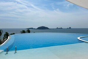 En swimmingpool med udsigt til havet og øer.
