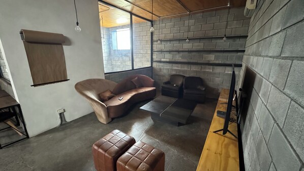 Ein modernes Wohnzimmer mit einer Couch, Sesseln und einem kleinen Tisch.