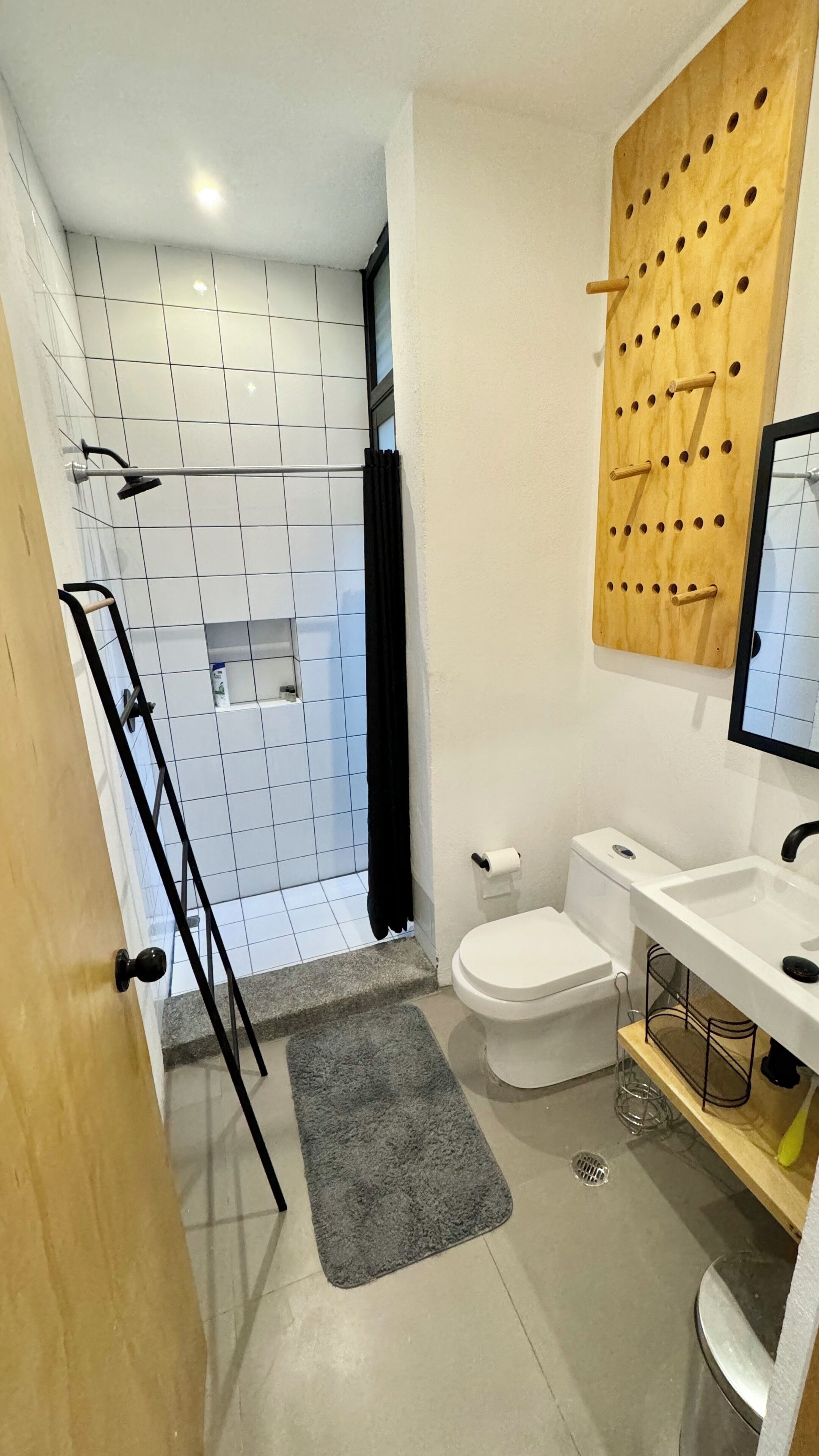 A modern bathroom with a shower, toilet, and sink.