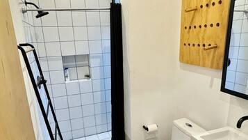 A modern bathroom with a shower, toilet, and sink.