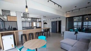 A modern interior with a dining area, bar, and seating space. - Studio 309 WBE São Paulo prx PUC Allianz (São Paulo)