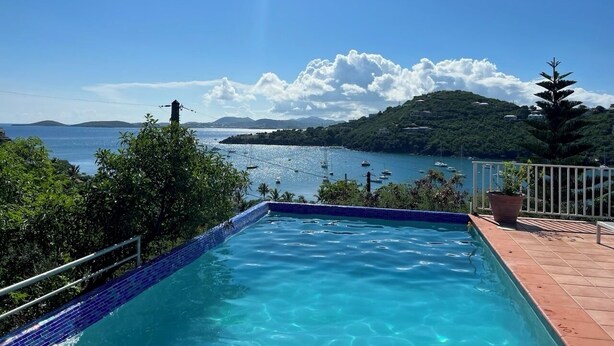 A swimming pool with a view of the sea and a mountainous landscape. - New rental, Newly Renovated 3br/2ba - open main room/beautiful view/large pool  (Cruz Bay)