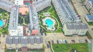 Ein Hochhaus-Hotel mit zwei Schwimmbecken, einem Innenhof und mehreren Parkebenen.